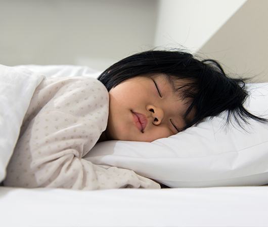 child fast asleep in bed after aiway management treatment