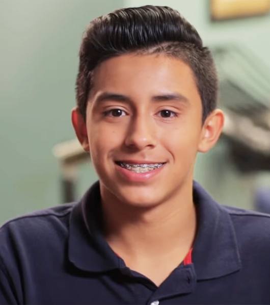 teen boy in polo shirt with braces smiling