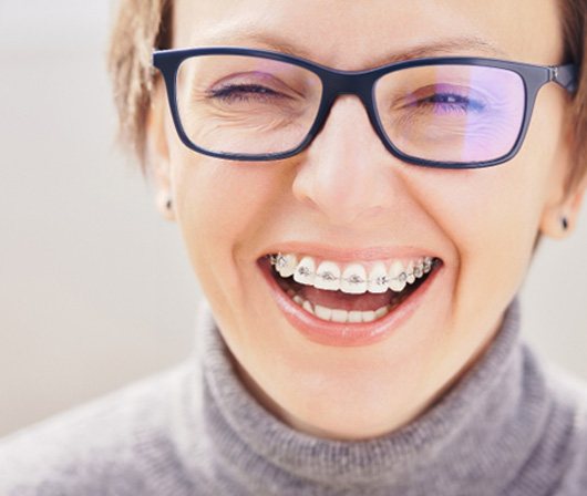 Adult female wearing metal braces and smiling 