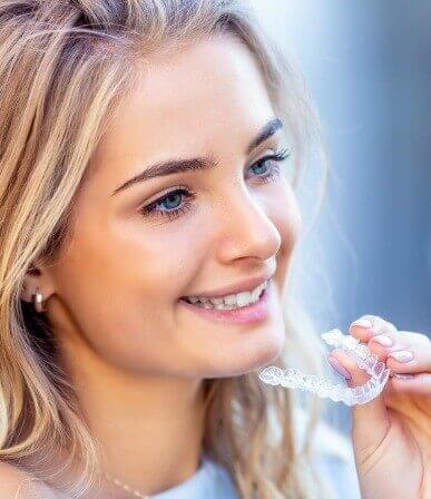 woman holding clear aligner