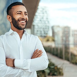 Man standing with arms crossed smiling after Invisalign in Dallas, TX