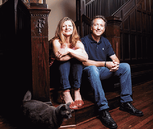 Doctor Simon sitting on stairs with her husband and cat