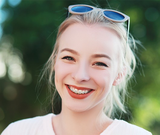 girl with sunglasses and traditional metal braces