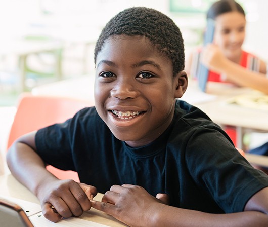 Young boy with braces in classroom at desk