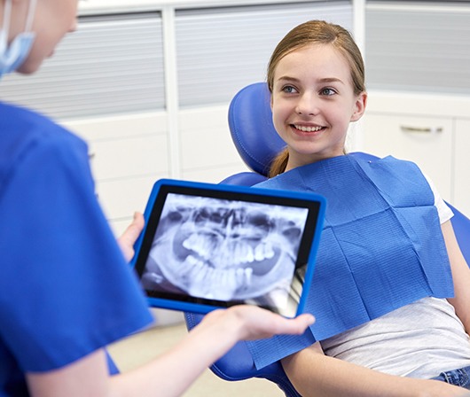 digital x-ray on tablet and patient smiling