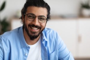 man with braces and glasses smiling 